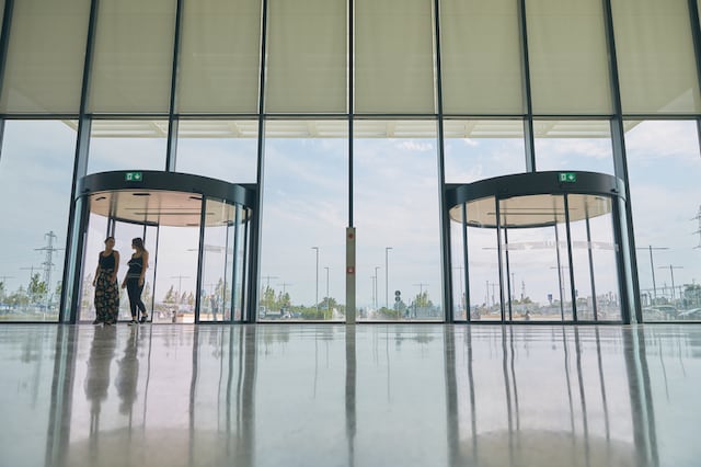 Two women approaching a revolving door